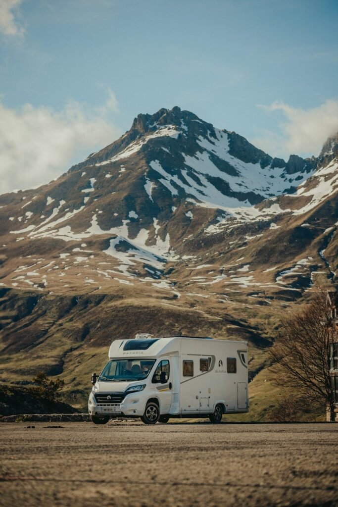 a white rv parked in front of a mountain range