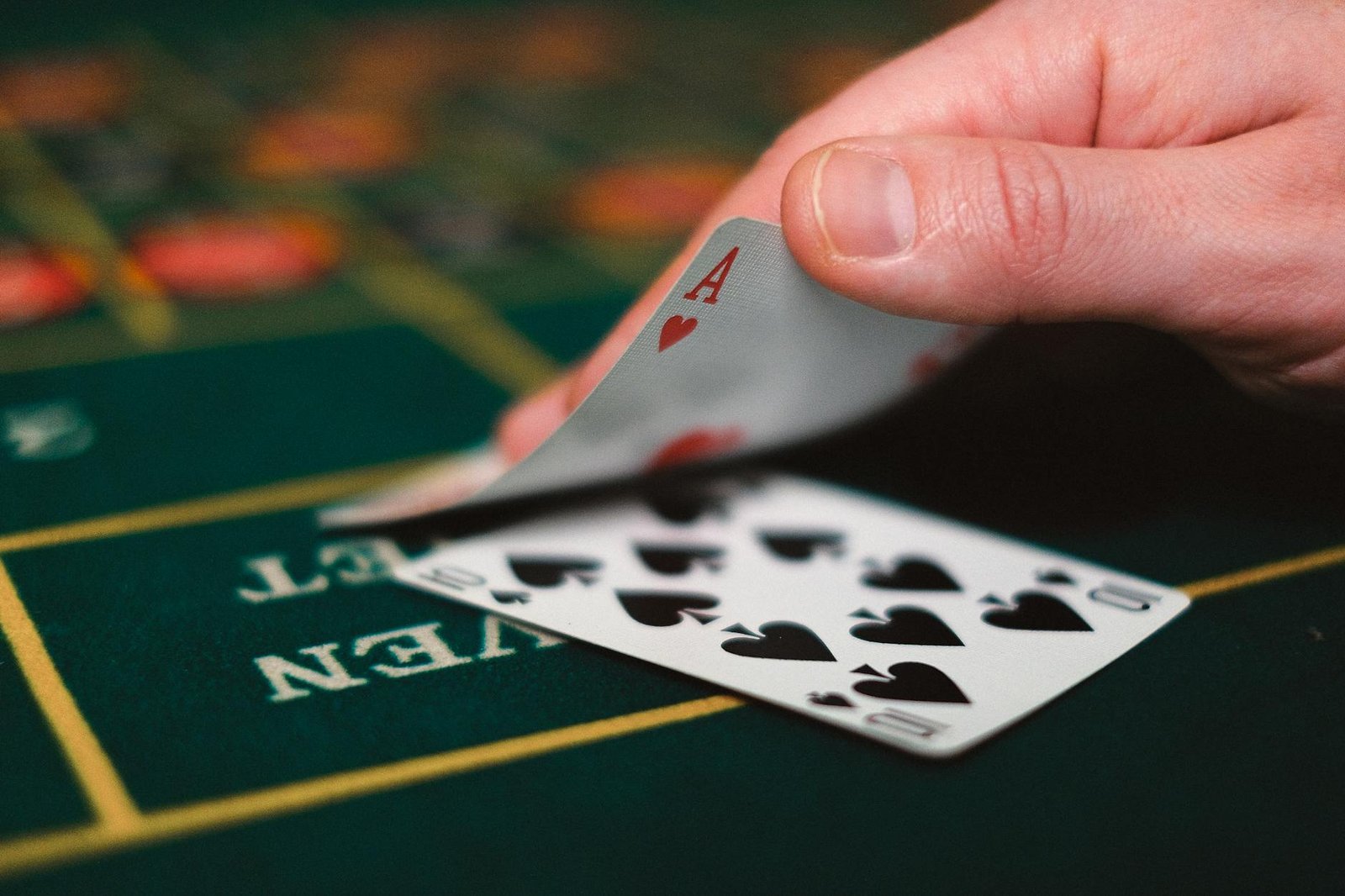 close up of person with cards in casino - poker combinations