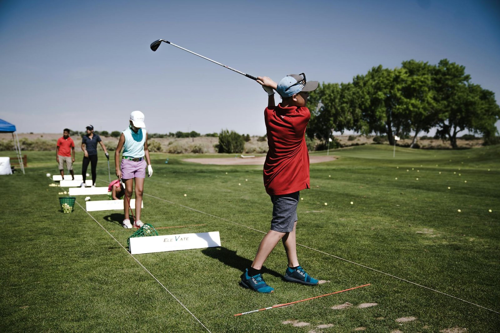 person swinging golf club on field