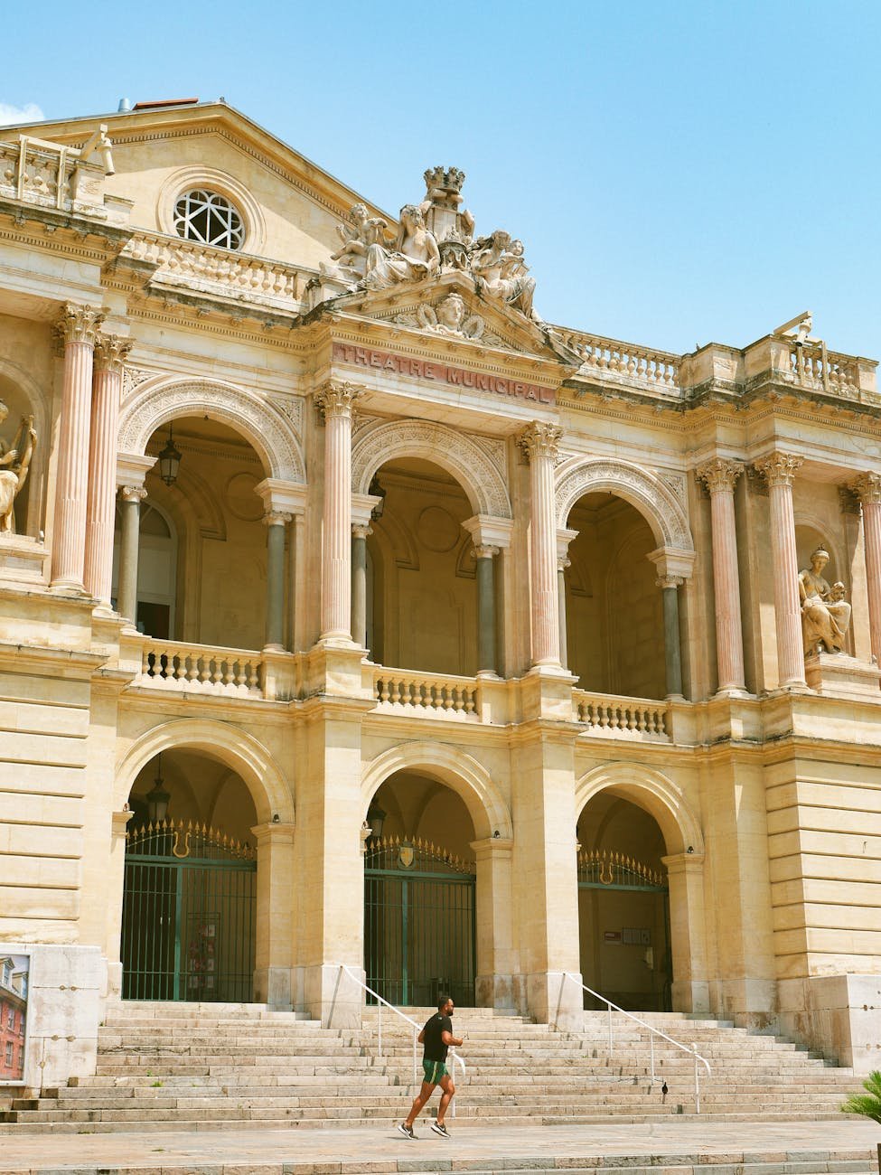 man running near facade of toulon opera