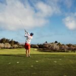 man in white t shirt playing golf